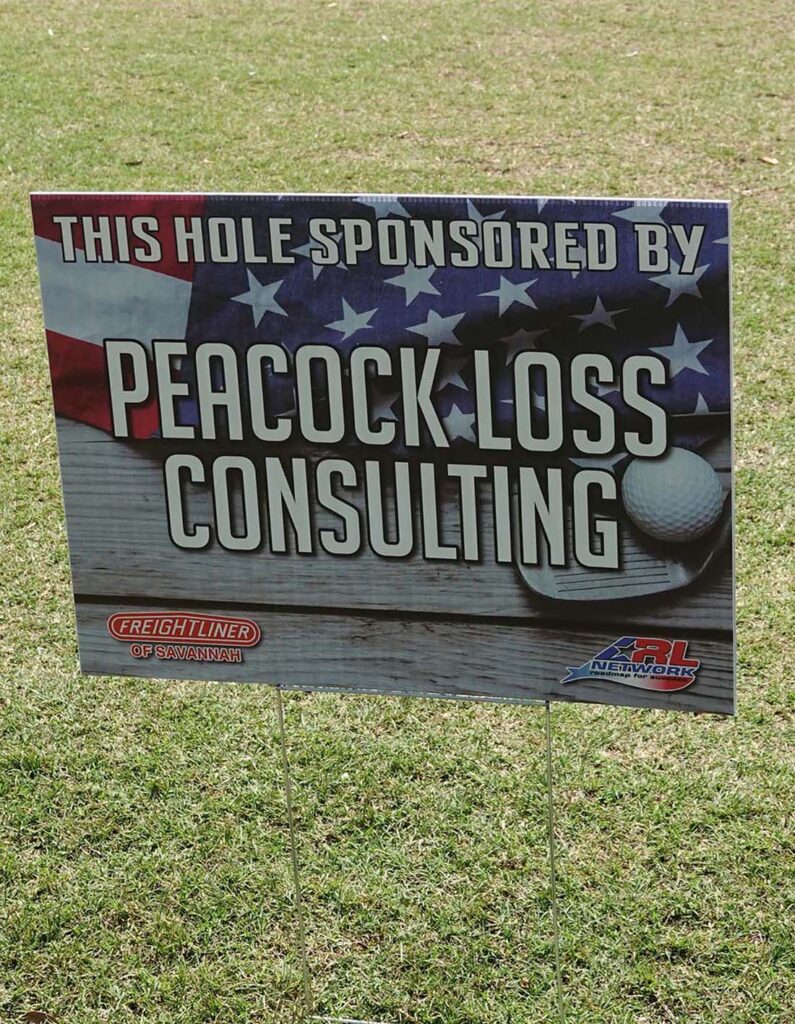 Peacock Loss Consulting advertising board with American flag