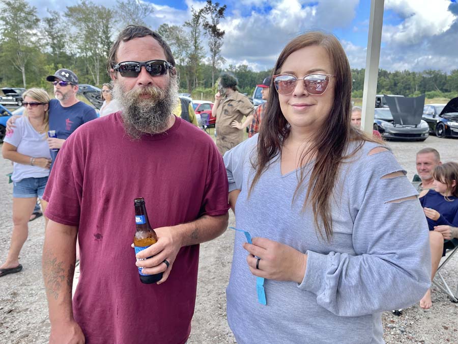 Man and woman outdoors at casual gathering.