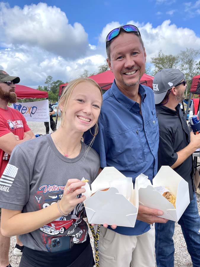 Smiling couple holding takeout boxes outdoors.