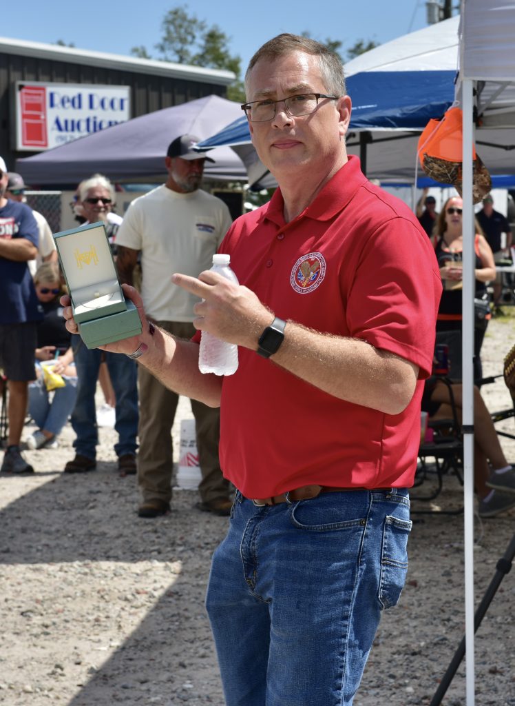 Man in red shirt holding a box.