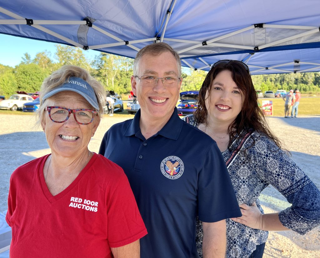 Smiling trio under pop-up tent